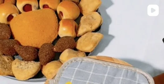 Mesa com salgados variados: coxinhas, quibes, enroladinhos e esfihas